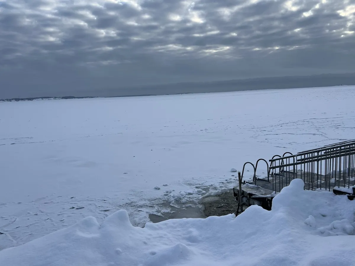 凍てつく海に開けられた氷の水風呂と手すり