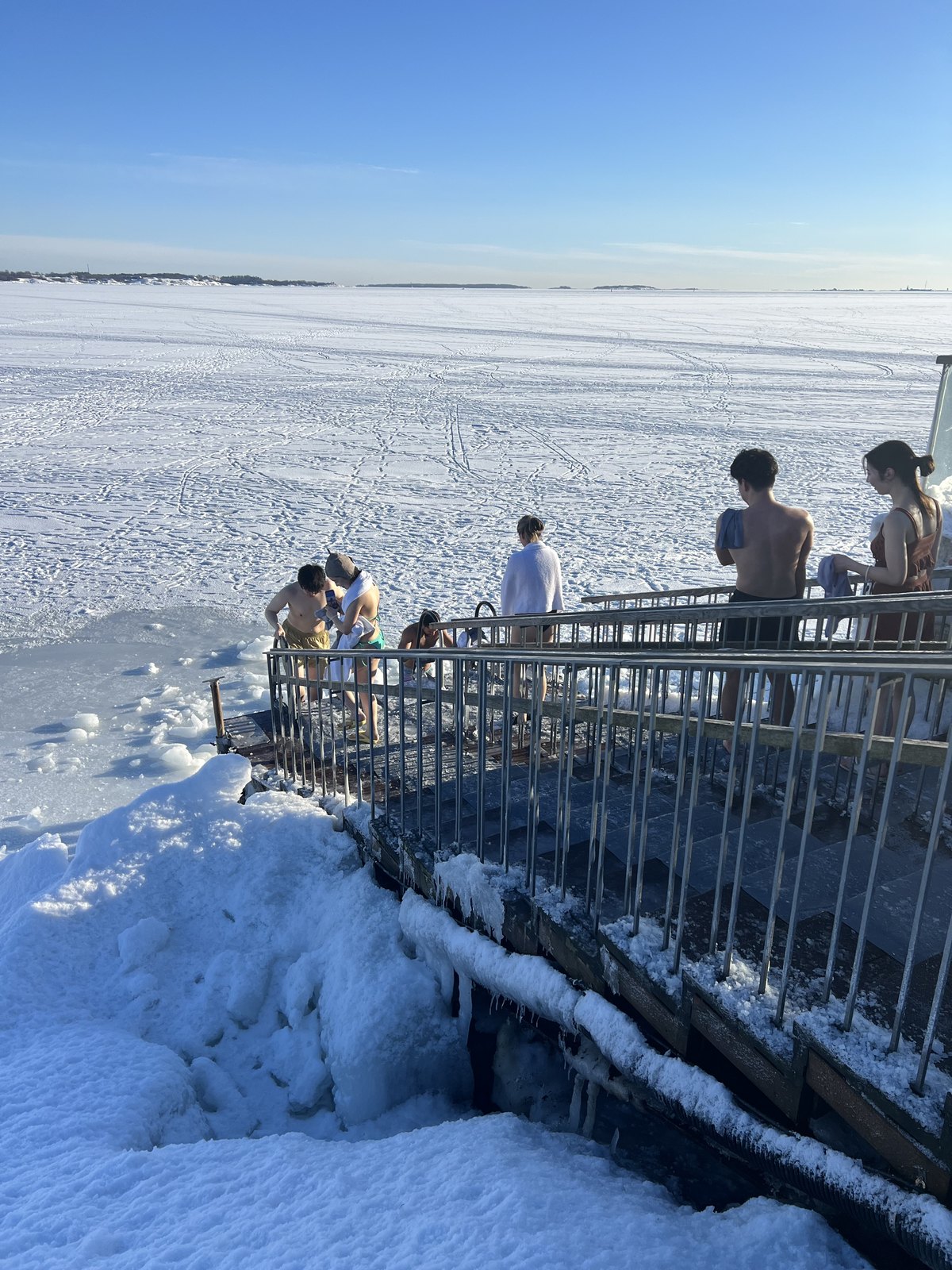 凍った海へ歩いて向かう氷水浴の入浴者たち