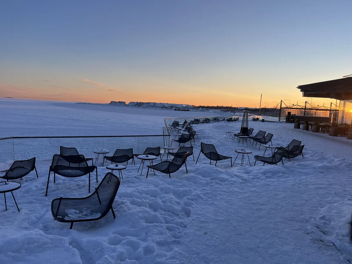 夕焼けの雪上に並ぶ外気浴用のラウンジチェア